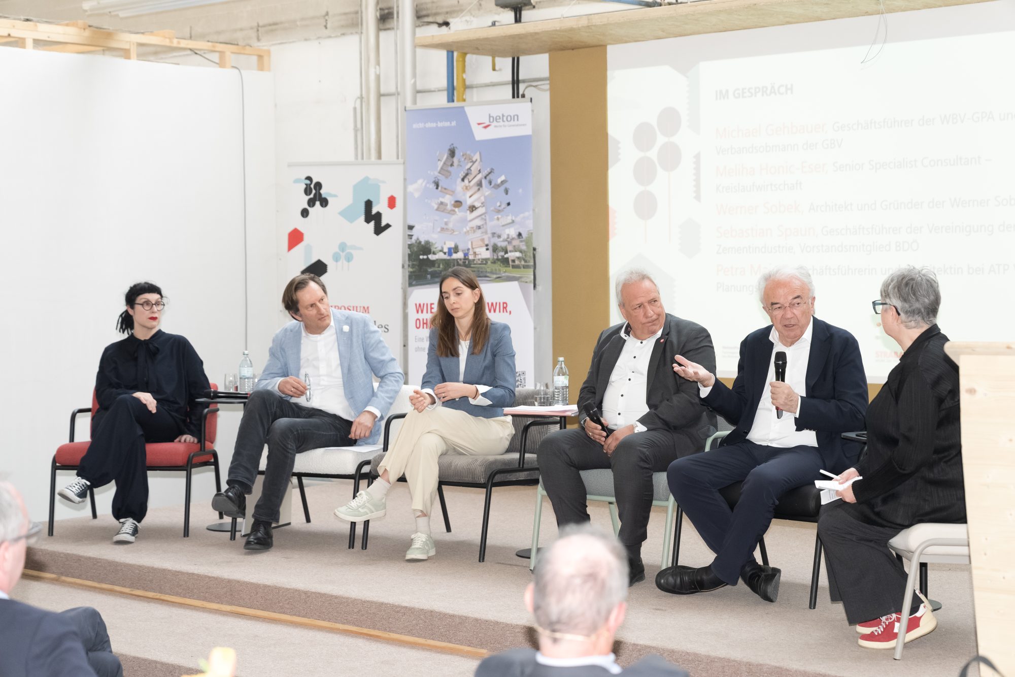 Drei Frauen und drei Männer diskutieren auf einem Podium miteinander