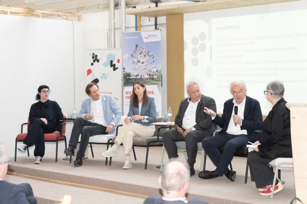 Drei Frauen und drei Männer diskutieren auf einem Podium miteinander