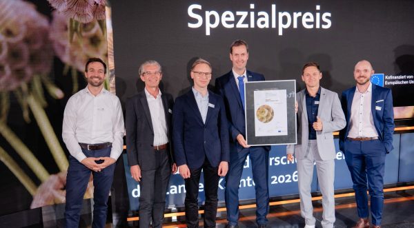 Fünf Männer freuen sich über die Übergabe einer Auszeichnung