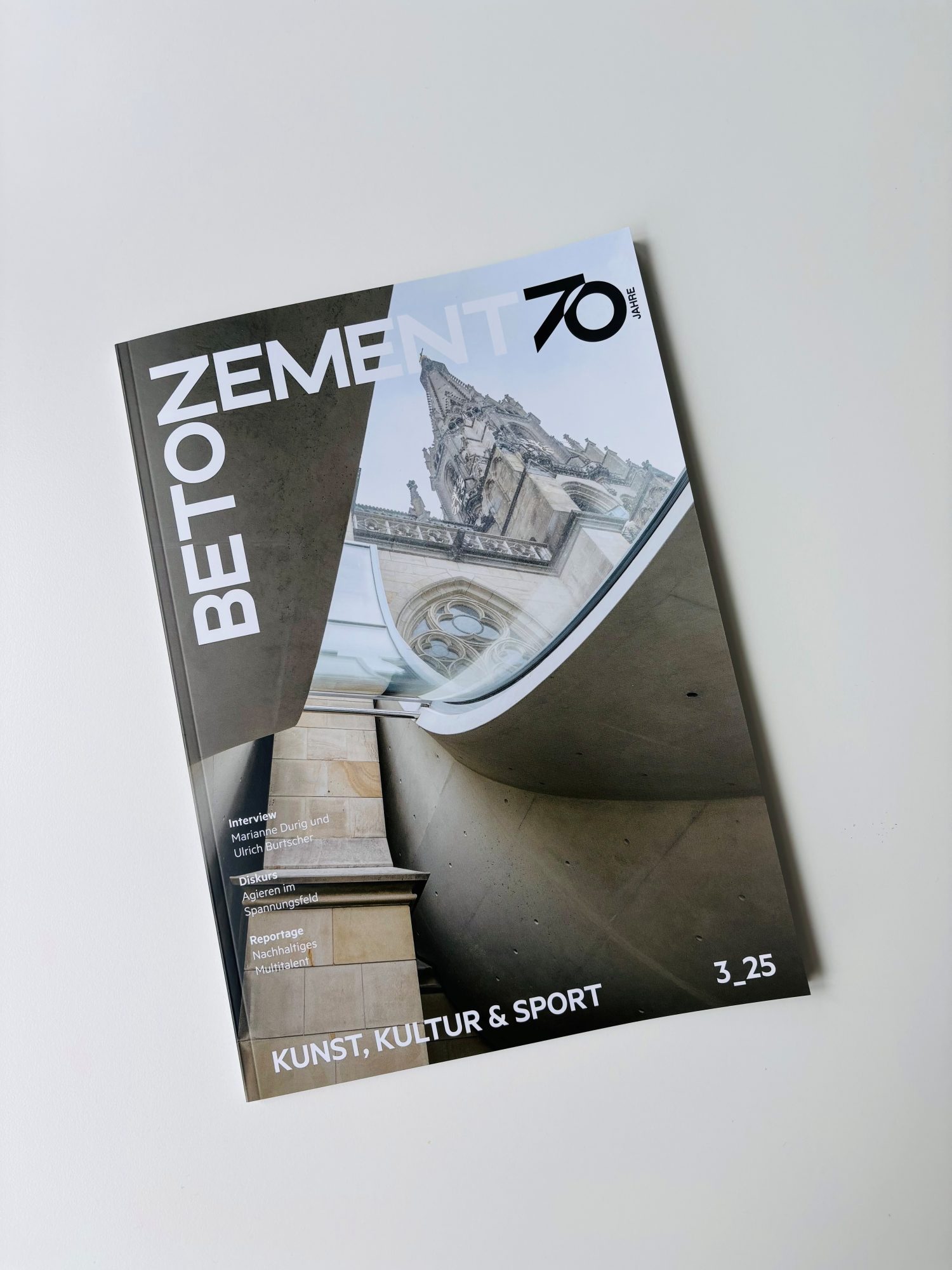 Magazin liegt auf einem Tisch, am Cover ist eine Kirche mit einem Betonvorbau