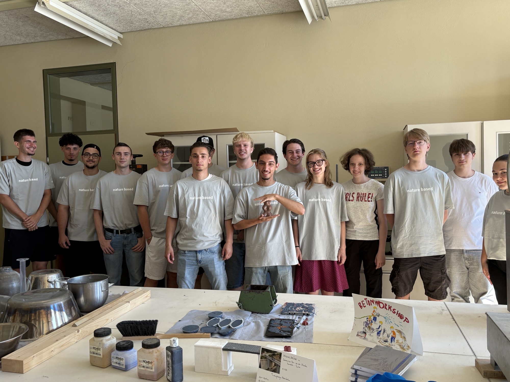 Gruppenfoto von Schülerinnen und Schülern mit Betonwerkstücken im Vordergrund