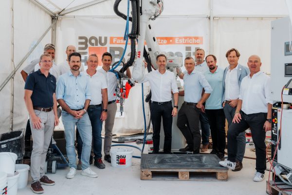 Eine Gruppe von Männern steht vor einer Baumaschine