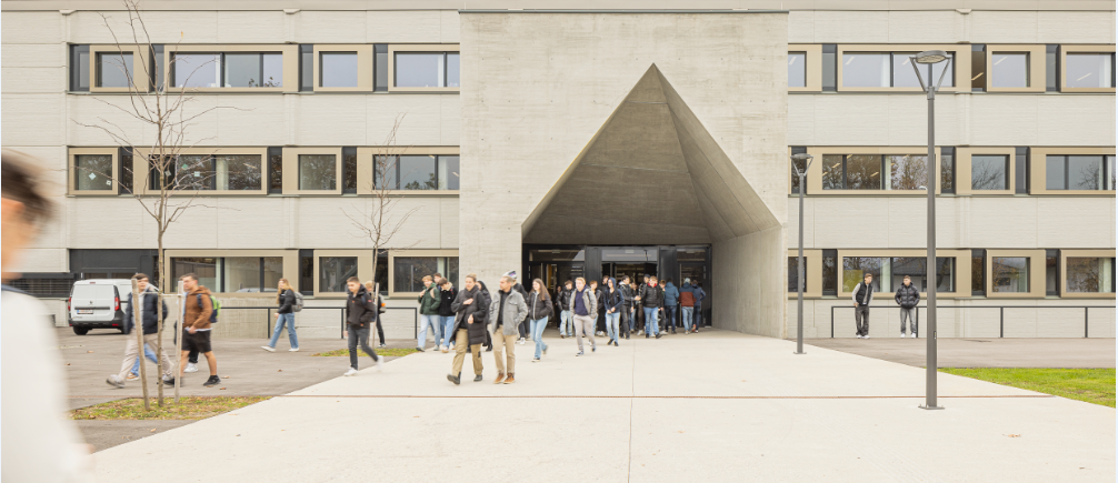 Erweiterte HTL Villach mit markantem Sichtbetonportal, Atrien und modernen Lernbereichen im Bestand