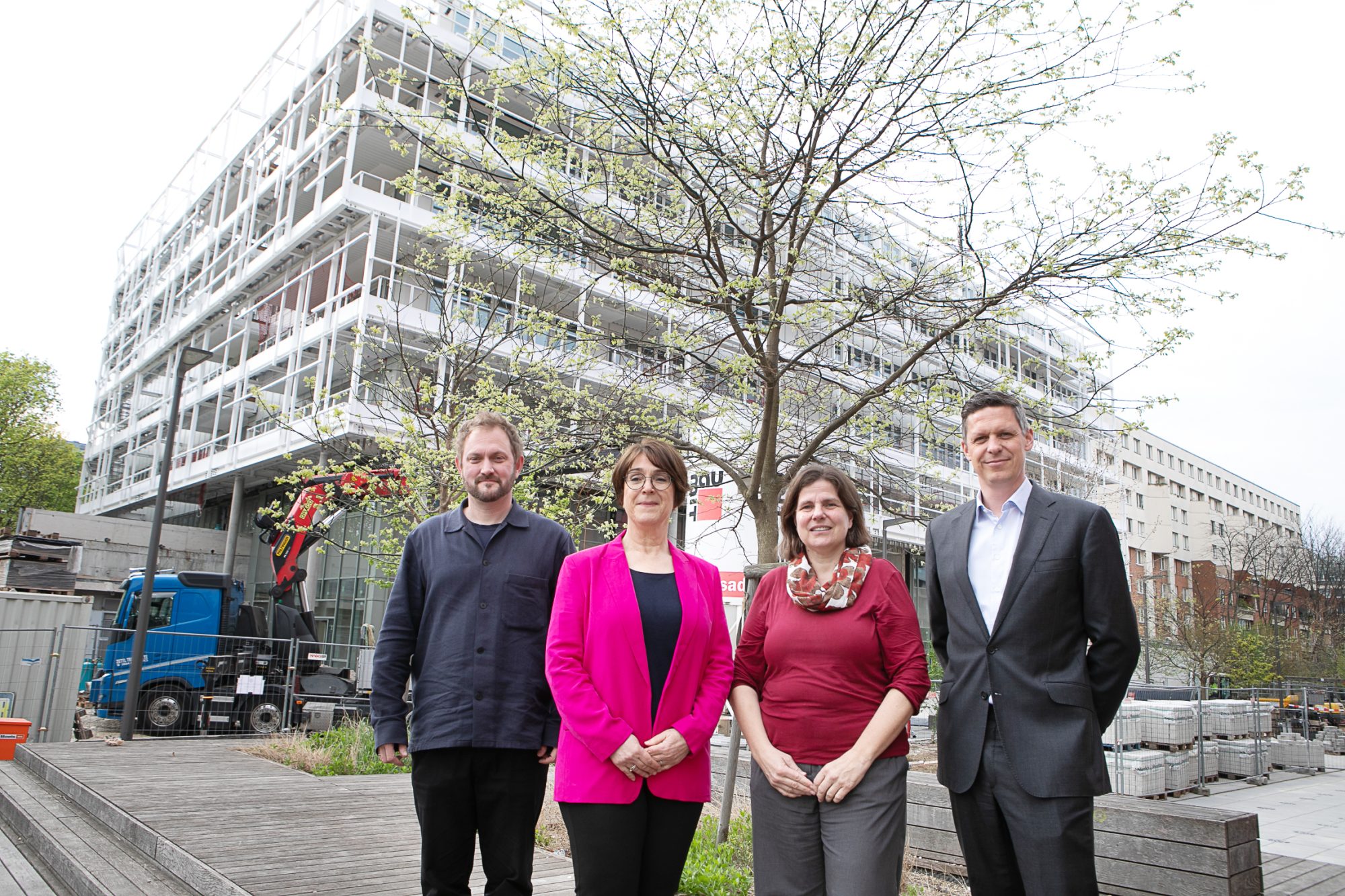 Vier Personen vor einem Gebäude an dem gearbeitet wird.